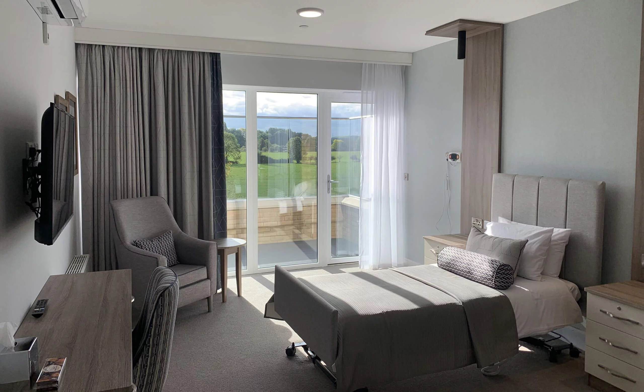 Resident’s bedroom at Castor Care Home with a glazed door onto a balcony